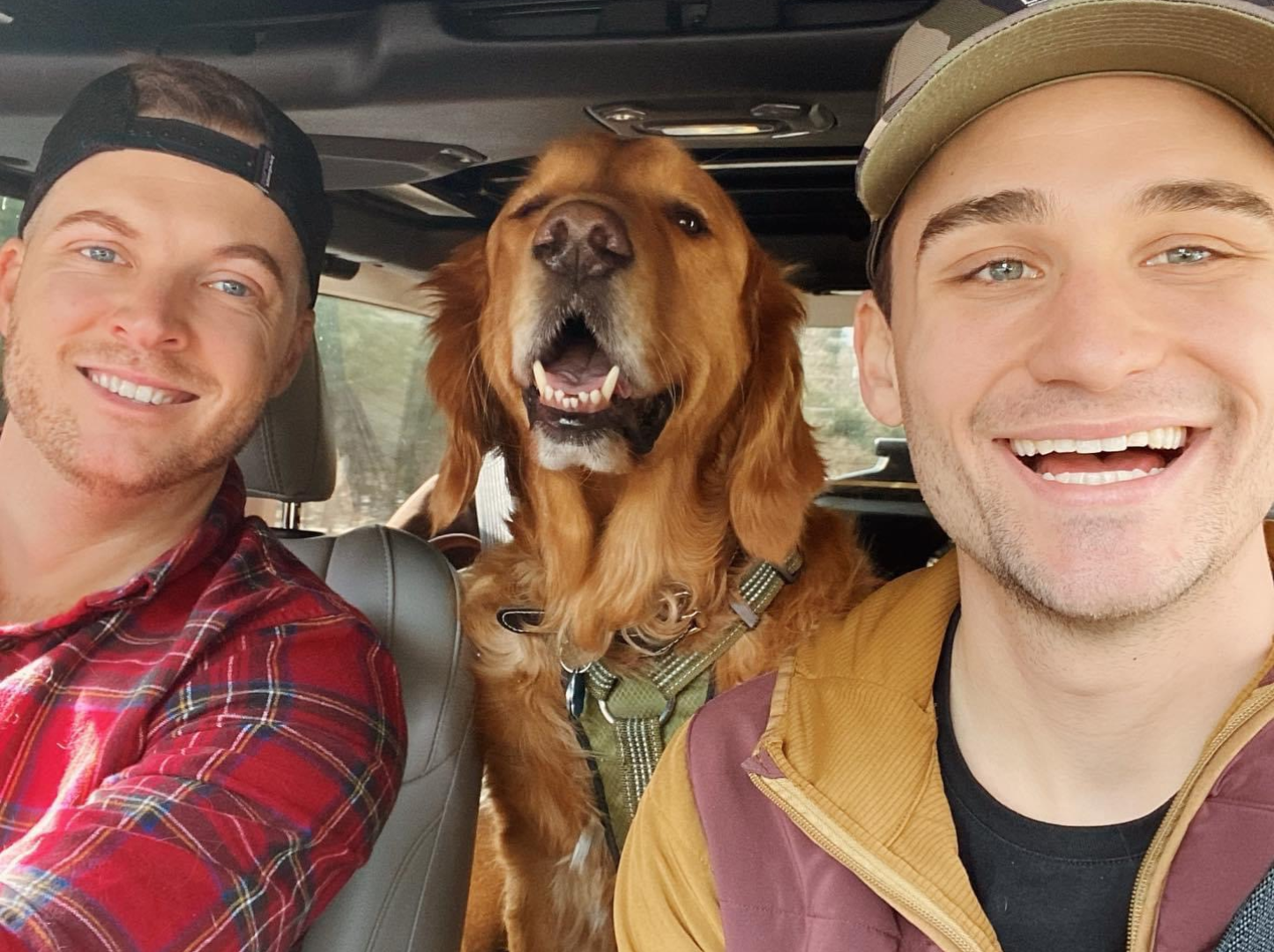 Two men and a dog in a car